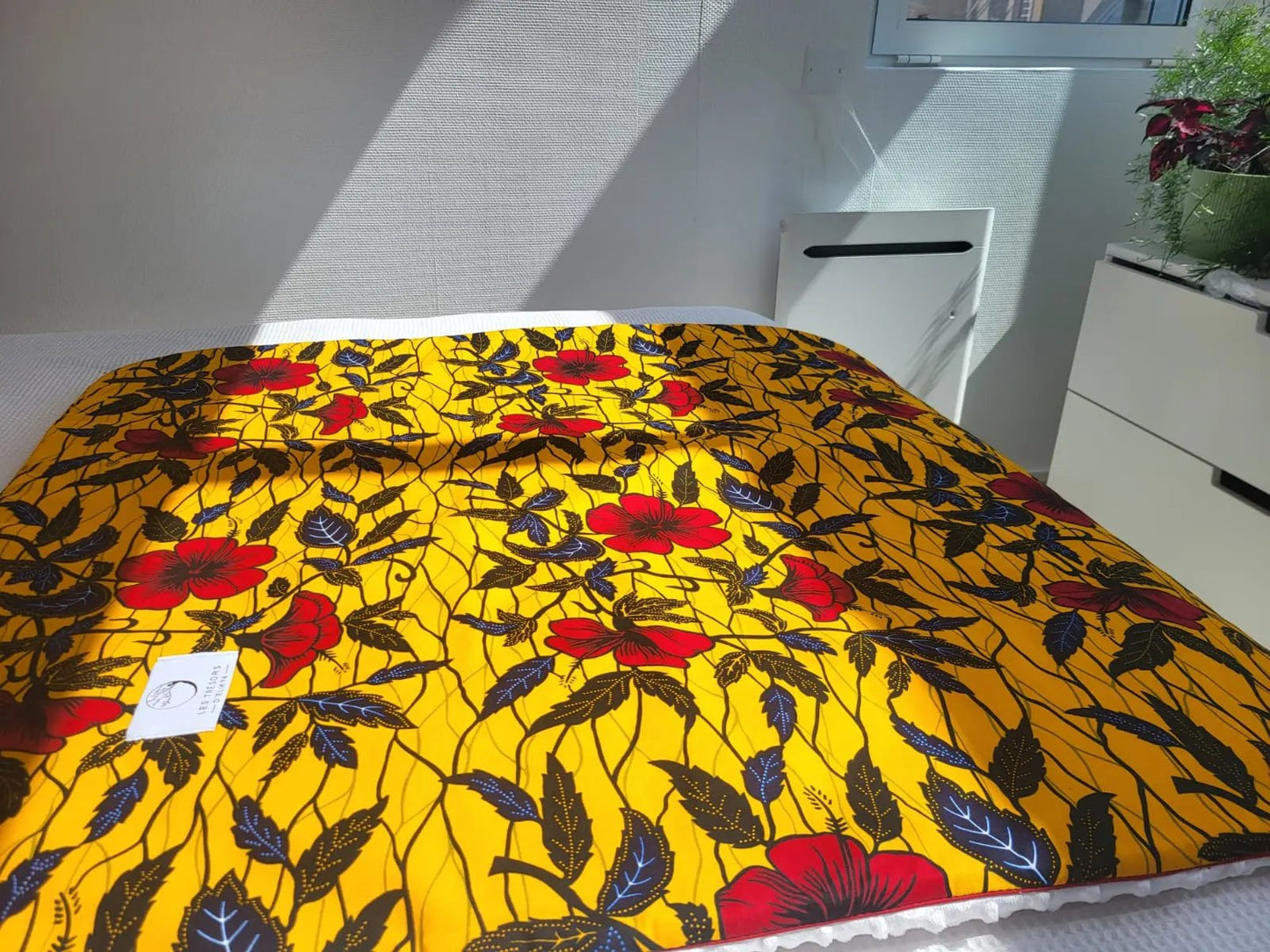 Couverture AYANA illuminée par la lumière du soleil – création artisanale en tissu wax africain et minky moelleux. Produit fait main Les Trésors d’Elikya, parfait pour offrir chaleur et confort à bébé.