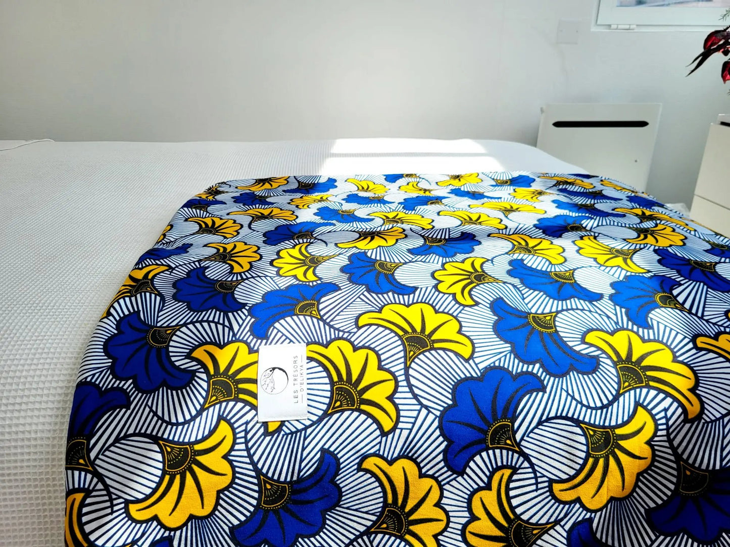 Couverture MIRELYS - illuminée par la lumière du soleil – création artisanale en tissu wax africain et minky moelleux. Produit fait main Les Trésors d’Elikya, parfait pour offrir chaleur et confort à bébé.