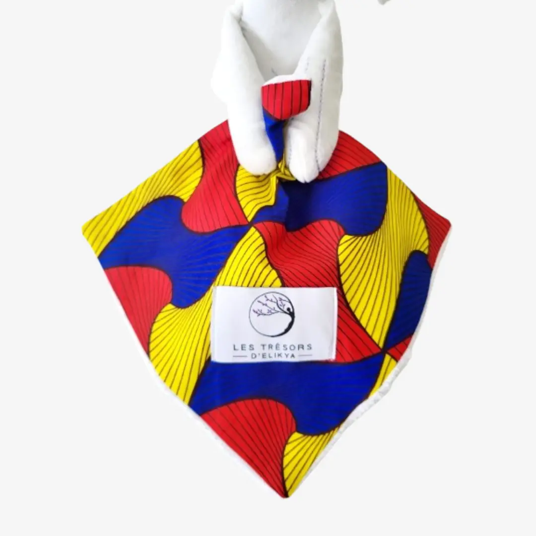 Zoom sur la couverture et l’étiquette du Bunny Wax AMORIA – doudou lapin bébé en tissu wax africain, création artisanale Les Trésors d’Elikya. Fait main avec soin, ce doudou éthique est un cadeau de naissance unique et durable.