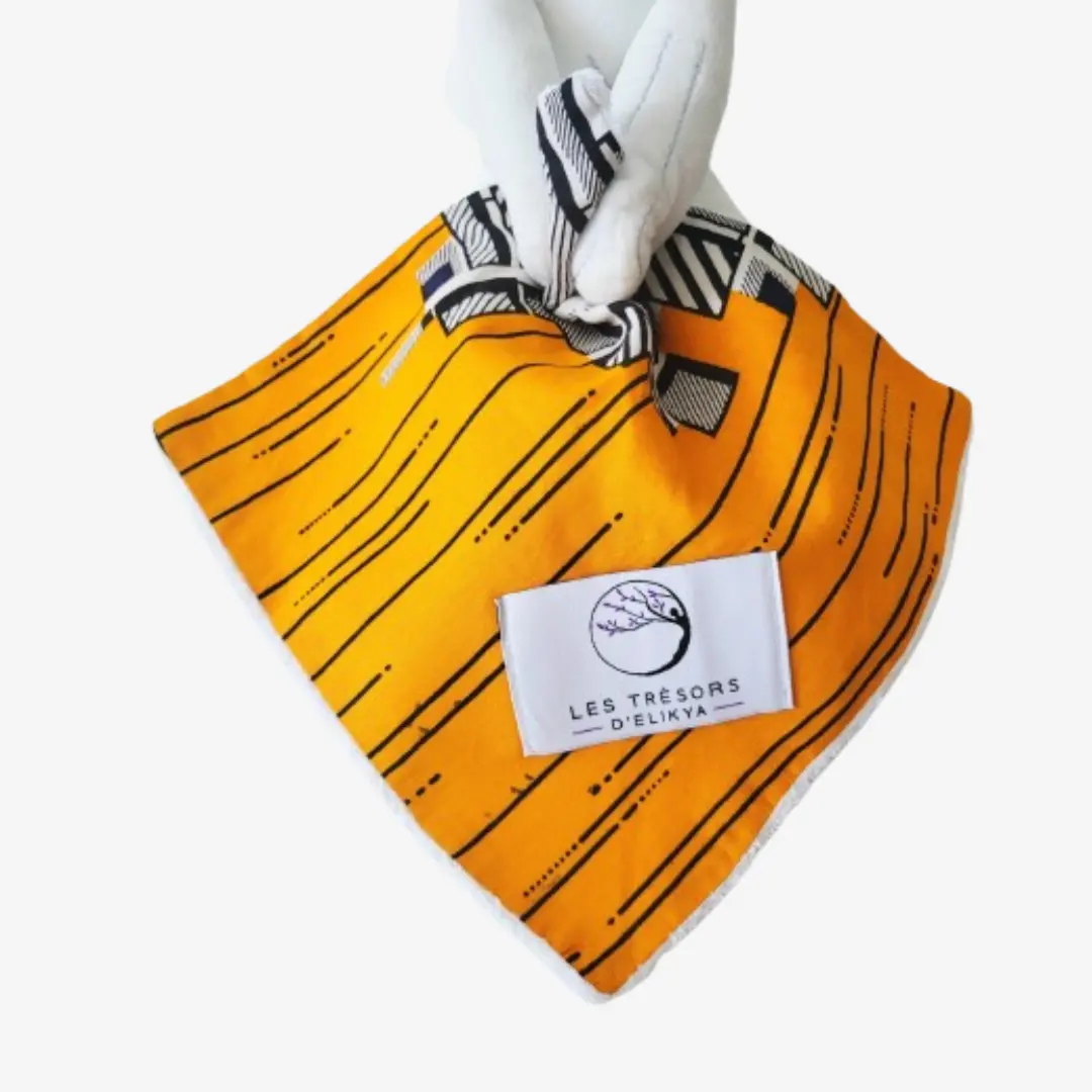 Zoom sur la couverture et l’étiquette du Bunny Wax KALINA – doudou lapin bébé en tissu wax africain, création artisanale Les Trésors d’Elikya. Fait main avec soin, ce doudou éthique est un cadeau de naissance unique et durable.