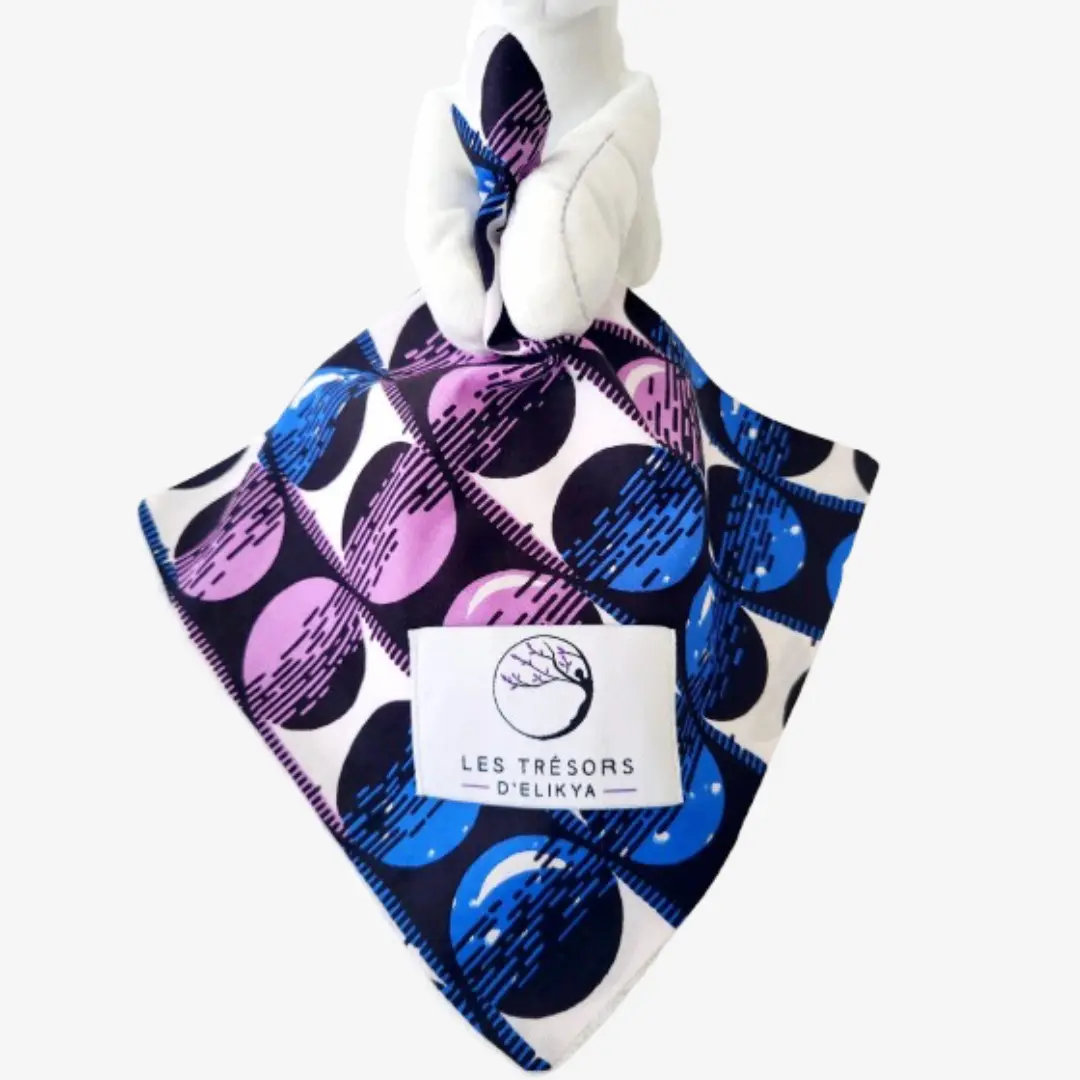 Zoom sur la couverture et l’étiquette du Bunny Wax NEBULYS – doudou lapin bébé en tissu wax africain, création artisanale Les Trésors d’Elikya. Fait main avec soin, ce doudou éthique est un cadeau de naissance unique et durable.