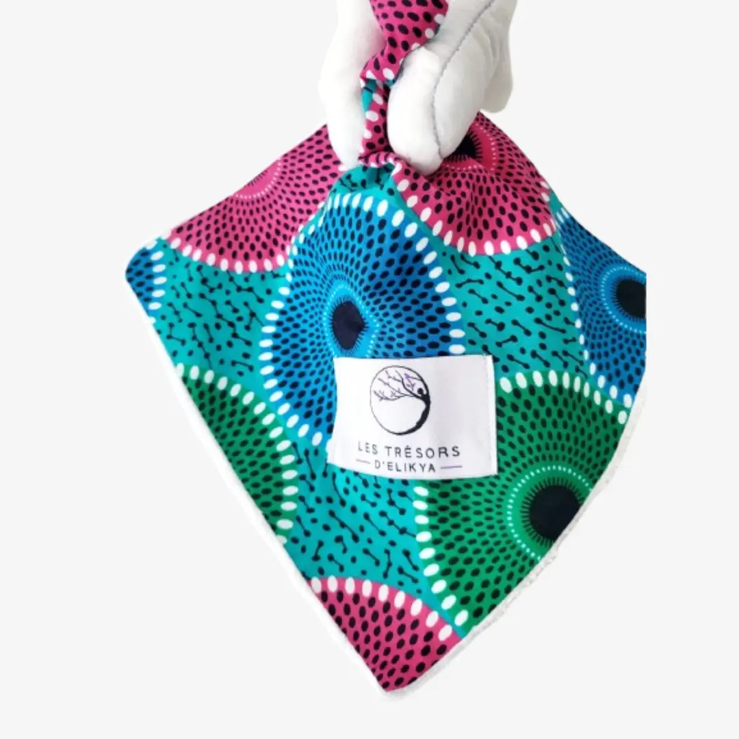 Zoom sur la couverture et l’étiquette du Bunny Wax ORELIOS – doudou lapin bébé en tissu wax africain, création artisanale Les Trésors d’Elikya. Fait main avec soin, ce doudou éthique est un cadeau de naissance unique et durable.