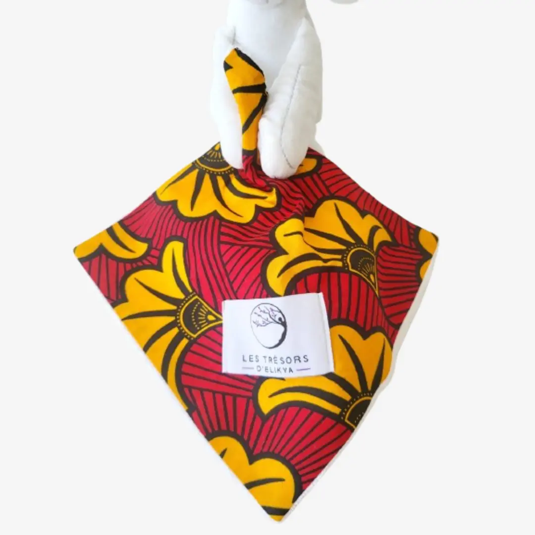 Zoom sur la couverture et l’étiquette du Bunny Wax SOLELYS – doudou lapin bébé en tissu wax africain, création artisanale Les Trésors d’Elikya. Fait main avec soin, ce doudou éthique est un cadeau de naissance unique et durable.