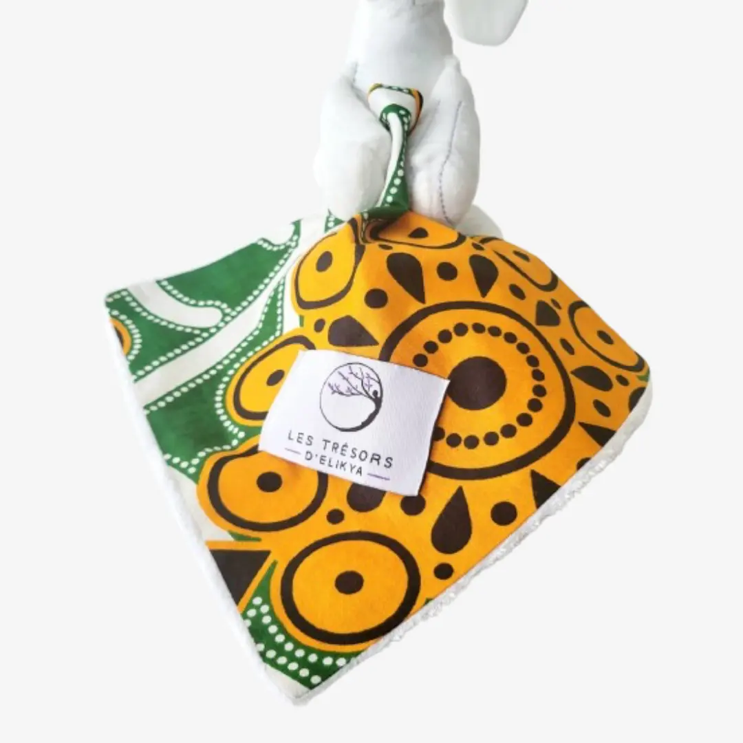 Zoom sur la couverture et l’étiquette du Bunny Wax ZAYANA – doudou lapin bébé en tissu wax africain, création artisanale Les Trésors d’Elikya. Fait main avec soin, ce doudou éthique est un cadeau de naissance unique et durable.