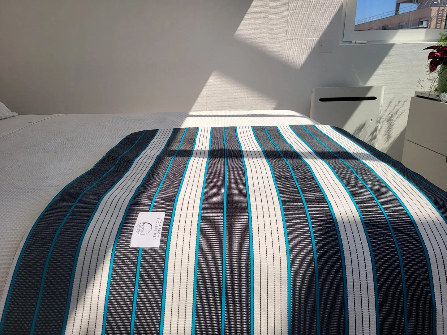 Couverture KOBA illuminée par la lumière du soleil – création artisanale en tissu wax africain et minky moelleux. Produit fait main Les Trésors d’Elikya, parfait pour offrir chaleur et confort à bébé.