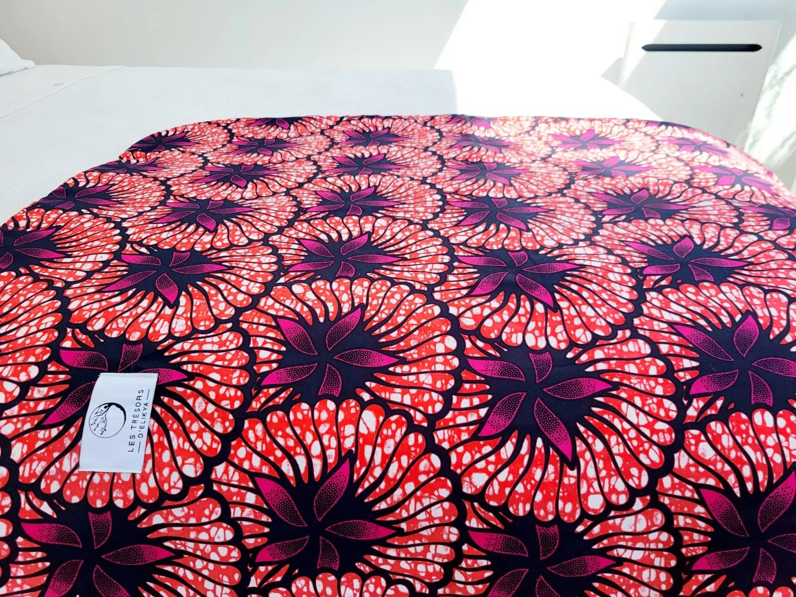 Couverture ROSÉLIA illuminée par la lumière du soleil – création artisanale en tissu wax africain et minky moelleux. Produit fait main Les Trésors d’Elikya, parfait pour offrir chaleur et confort à bébé.