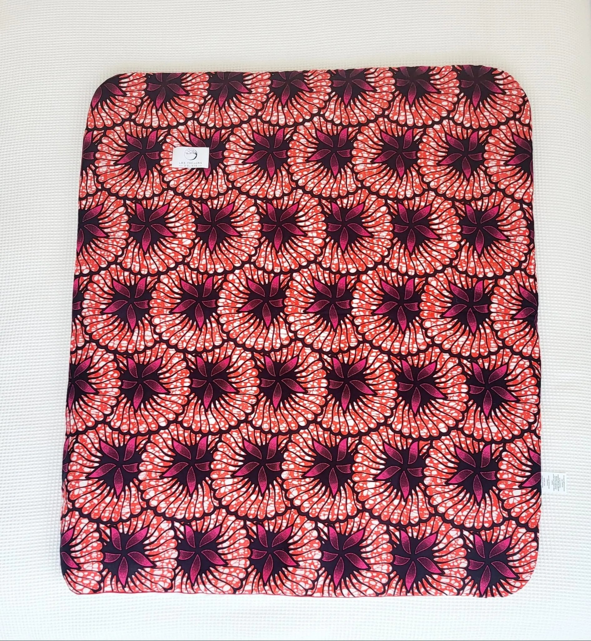 Vue complète de la couverture ROSÉLIA – face en tissu wax africain aux tons rose, noir et blanc, confection artisanale Les Trésors d’Elikya. Couverture bébé douce, moelleuse et raffinée, idéale comme cadeau de naissance.