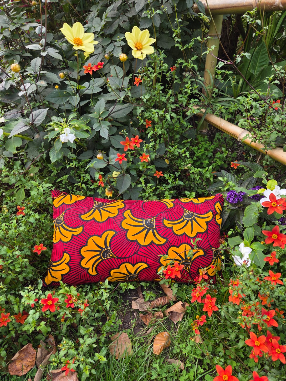 Coussin déco assorti du coffret cadeau SOLÉLYS, en Wax jaune et rouge éclatant.