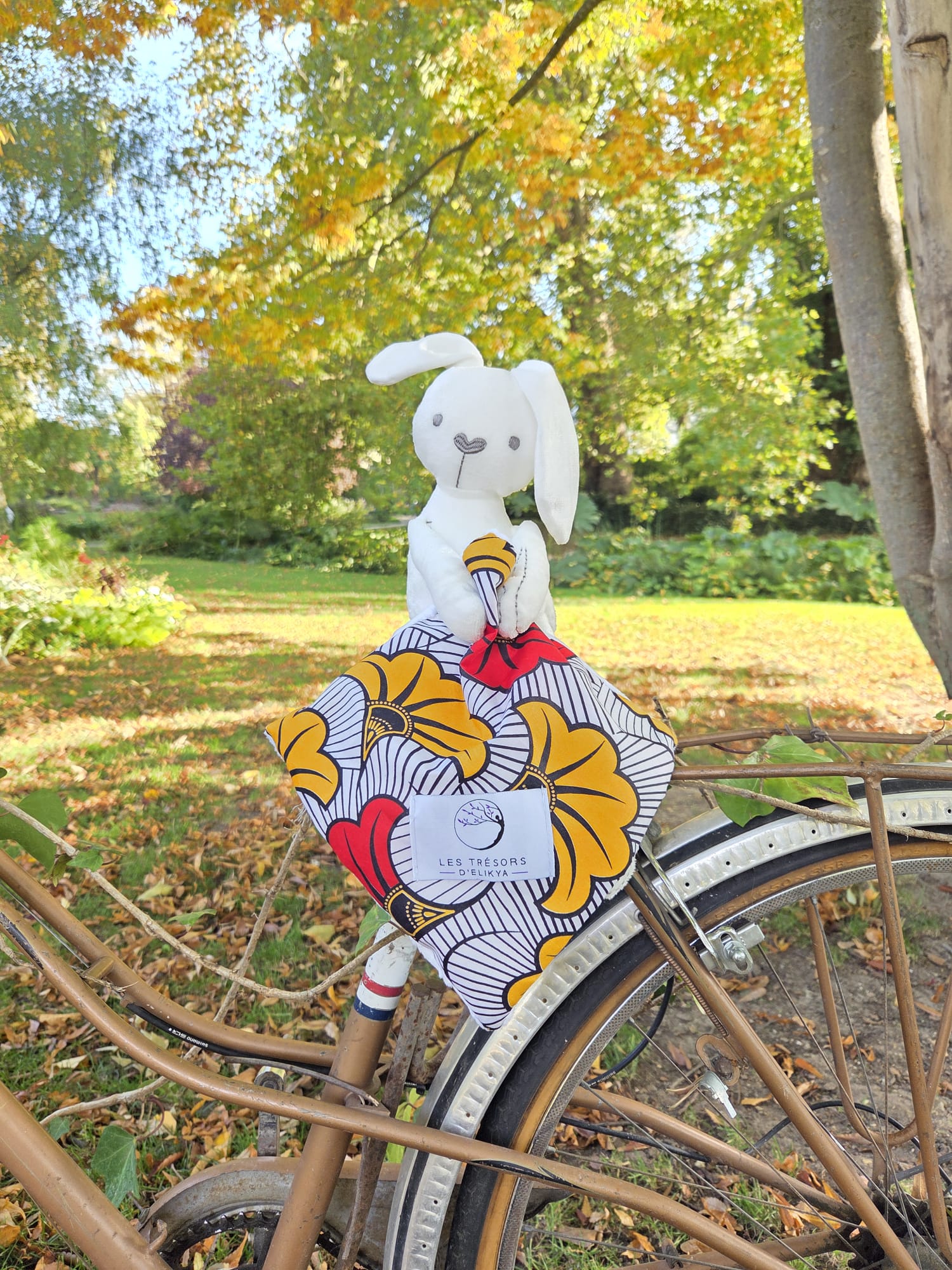 Doudou du coffret cadeau d’éveil RUBÉLYS, en tissu Minky et Wax fleuri rouge et jaune.