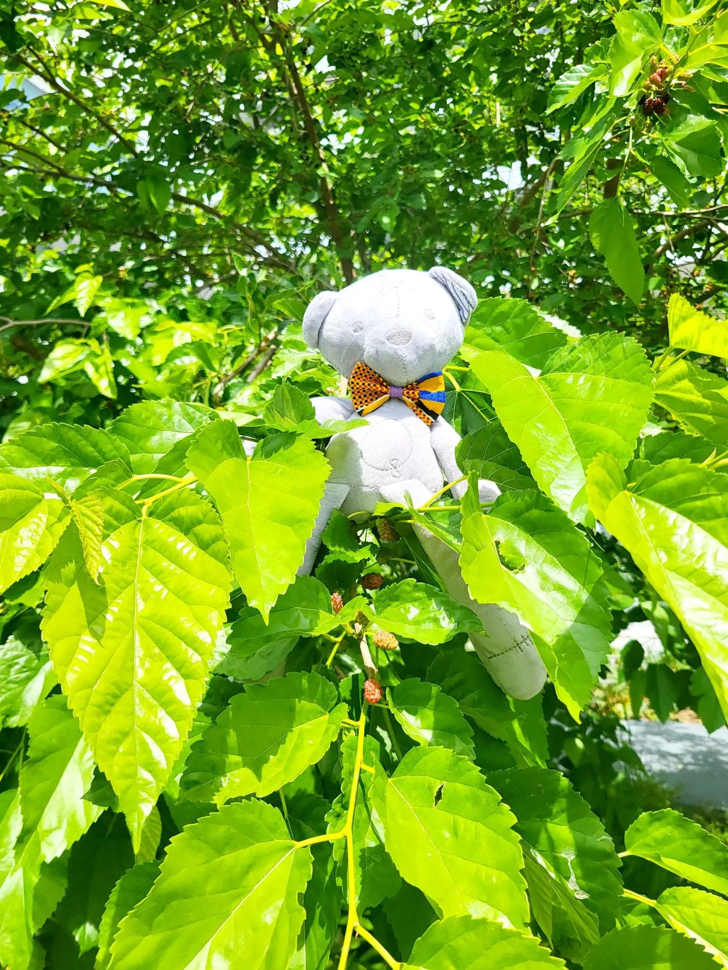 Ours en peluche Teddy Wax KENZAO avec nœud papillon orange en tissu Wax – création artisanale Les Trésors d’Elikya